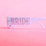 Pearl white bride sunglasses with silver BRIDE lettering and light grey lenses