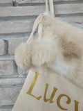 Ivory Christmas stocking hanging with metallic gold HTV vinyl personalization and soft faux fur cuff