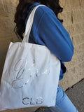 White bag with 'CLB' branding on a textured surface