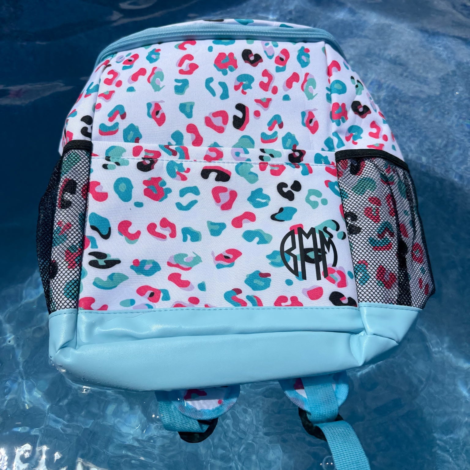 Backpack with colorful leopard print pattern on a blue surface