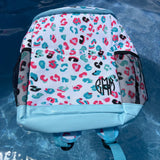 Backpack with colorful leopard print pattern on a blue surface