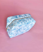 White makeup bag with an all-over light blue bow pattern, featuring a rectangular shape and zippered closure — perfect for brides and travel use.