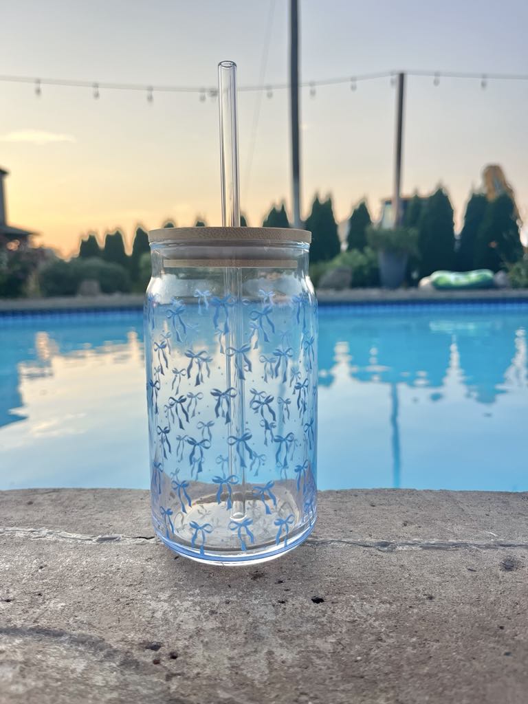 Clear 16oz glass cup with bamboo lid and straw featuring a blue bow pattern, perfect for iced coffee and bridal gifts.