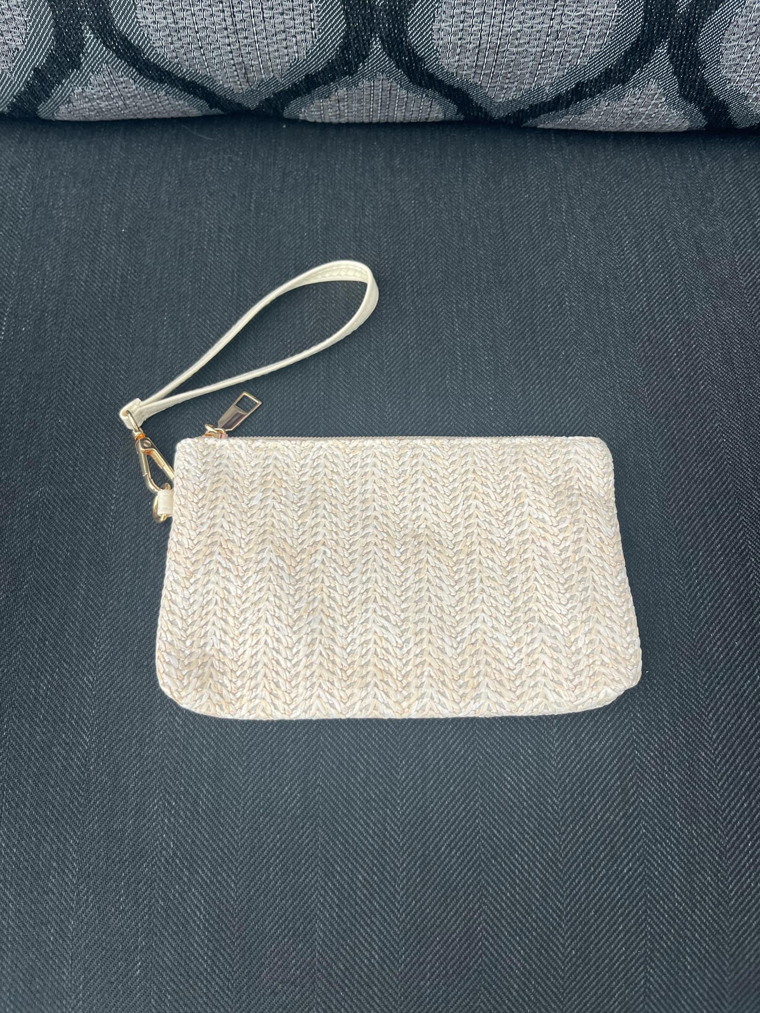 Textured pouch with a strap on a dark fabric background