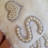 White fluffy slipper close up with decorative pearl and rhinestone details