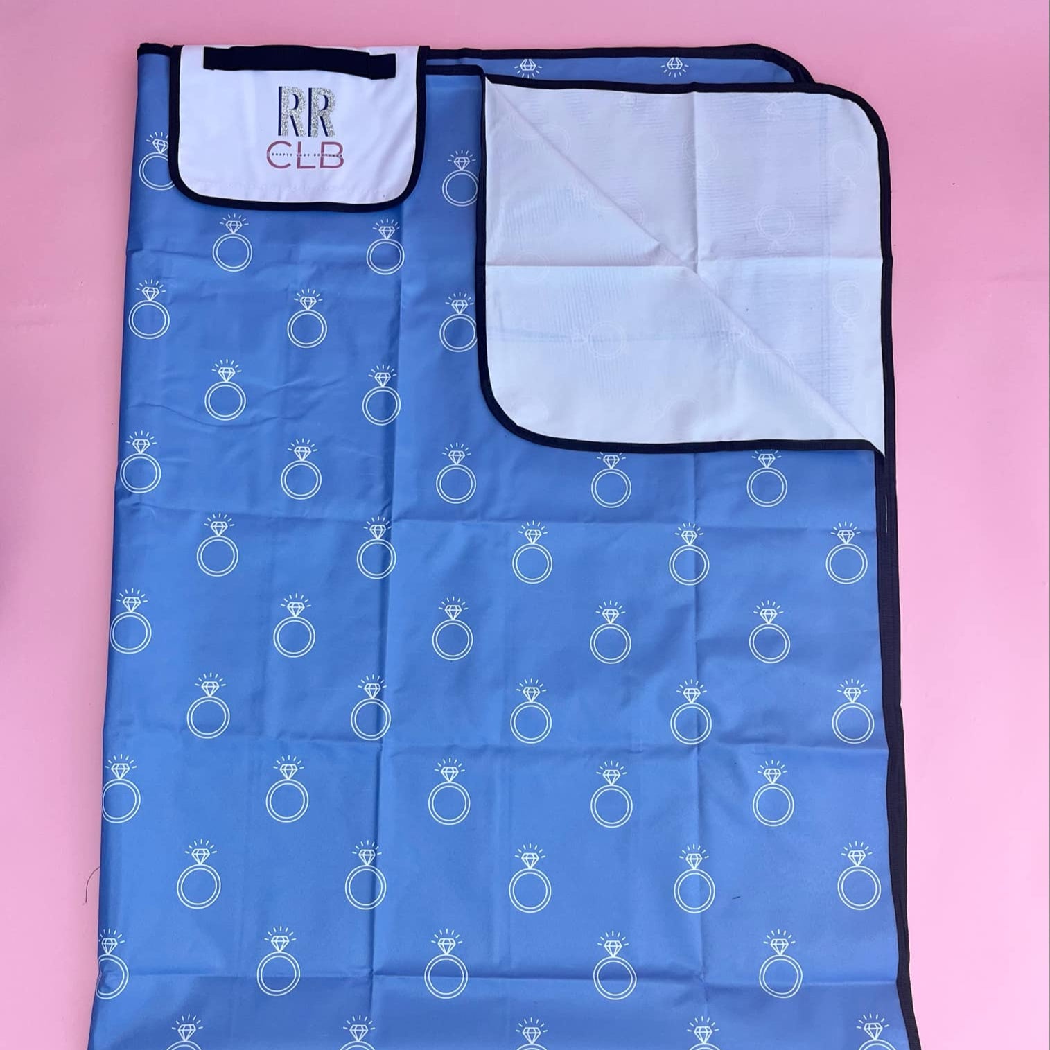 Foldable picnic mat with blue engagement ring print, white inner lining, and personalized flap—perfect for brides, wives, or bridal party outings.