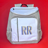 Gray and white monogrammed cooler backpack with glitter initials, featuring insulated compartments and mesh side pockets, perfect for brides and wives.
