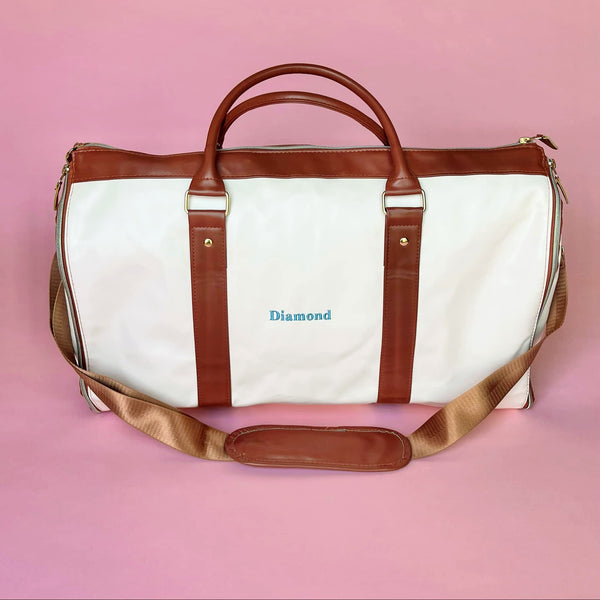 White and brown foldable weekender travel bag with leather-style straps, perfect for brides on the go.