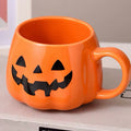 An orange pumpkin-shaped ceramic mug with a black jack-o'-lantern face, resting on a gray book with an open book in front, against a neutral background.