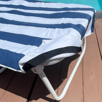 Navy and white striped lounge chair towel cover with side pockets, displayed poolside—perfect for brides and wives on honeymoon or summer getaways.