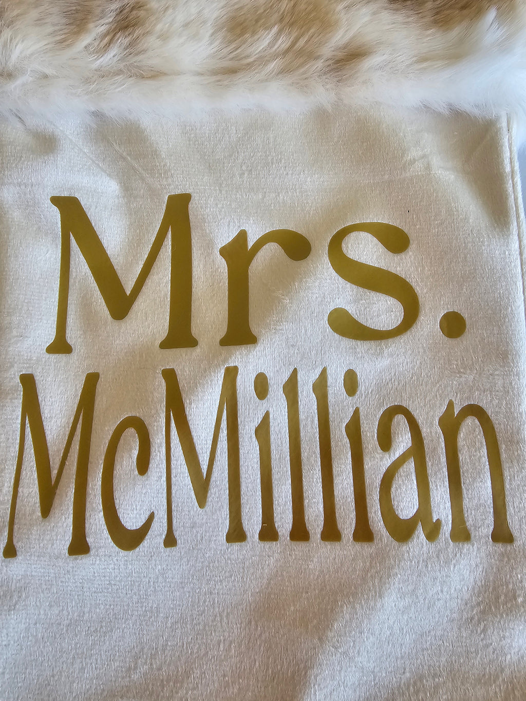 White stocking with 'Mrs. McMillian'  on a fluffy white surface