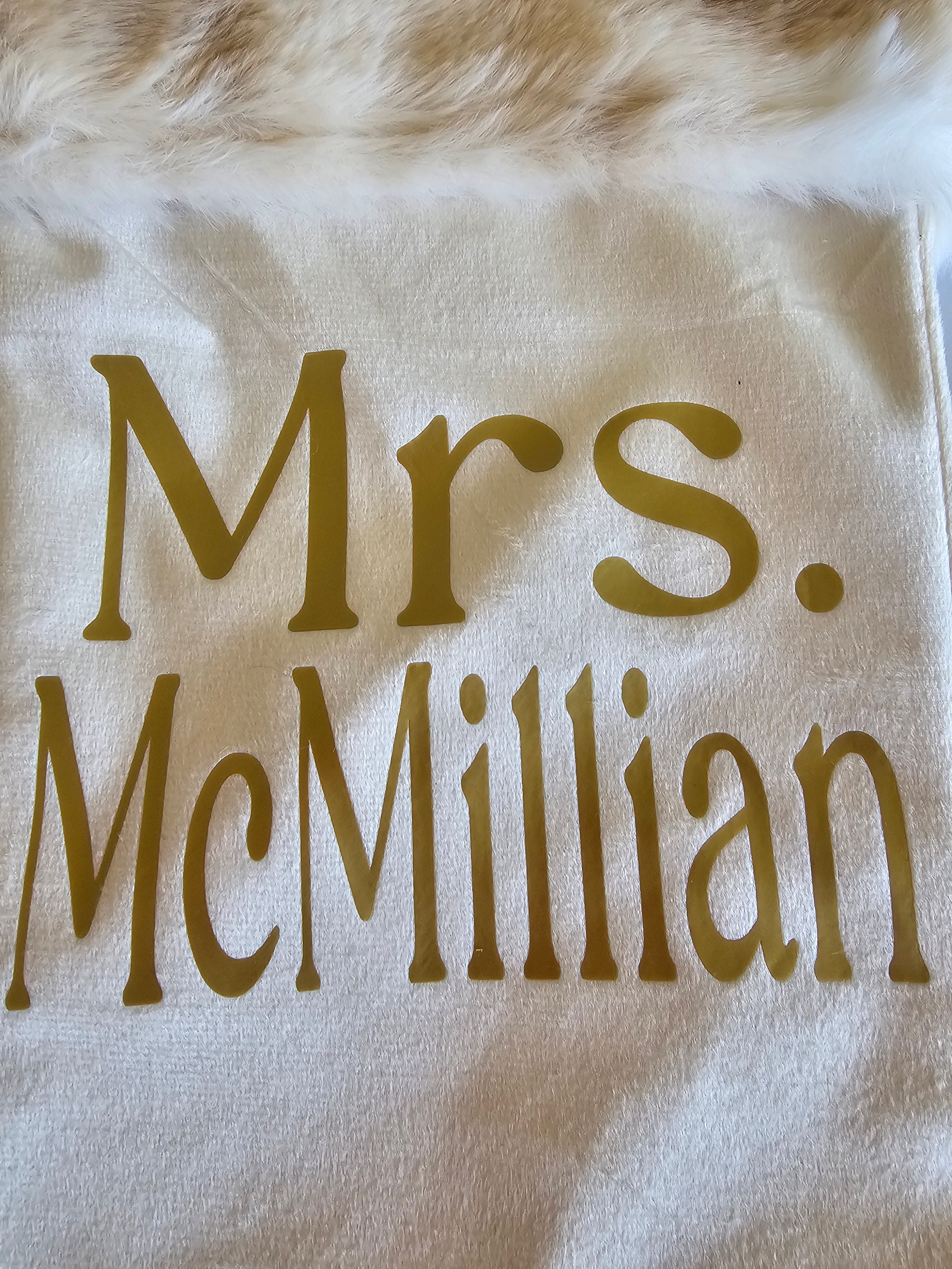 White stocking with 'Mrs. McMillian'  on a fluffy white surface