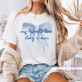 White t-shirt with a large blue bow and the phrase “my favorite love story is ours”—perfect for brides, wives, and romantic occasions.