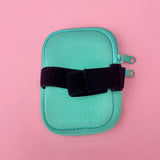 Mint green tumbler pouch with glitter monogram, securely wrapped around a textured blue tumbler, perfect for brides to carry small essentials hands-free.