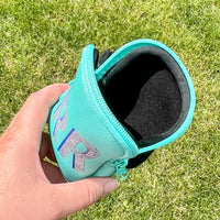 Mint green tumbler pouch with glitter monogram, securely wrapped around a textured blue tumbler, perfect for brides to carry small essentials hands-free.