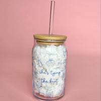 Clear glass cup with bamboo lid and straw featuring blue “She’s Tying the Knot” text and wedding doodles, perfect for brides and iced coffee lovers.