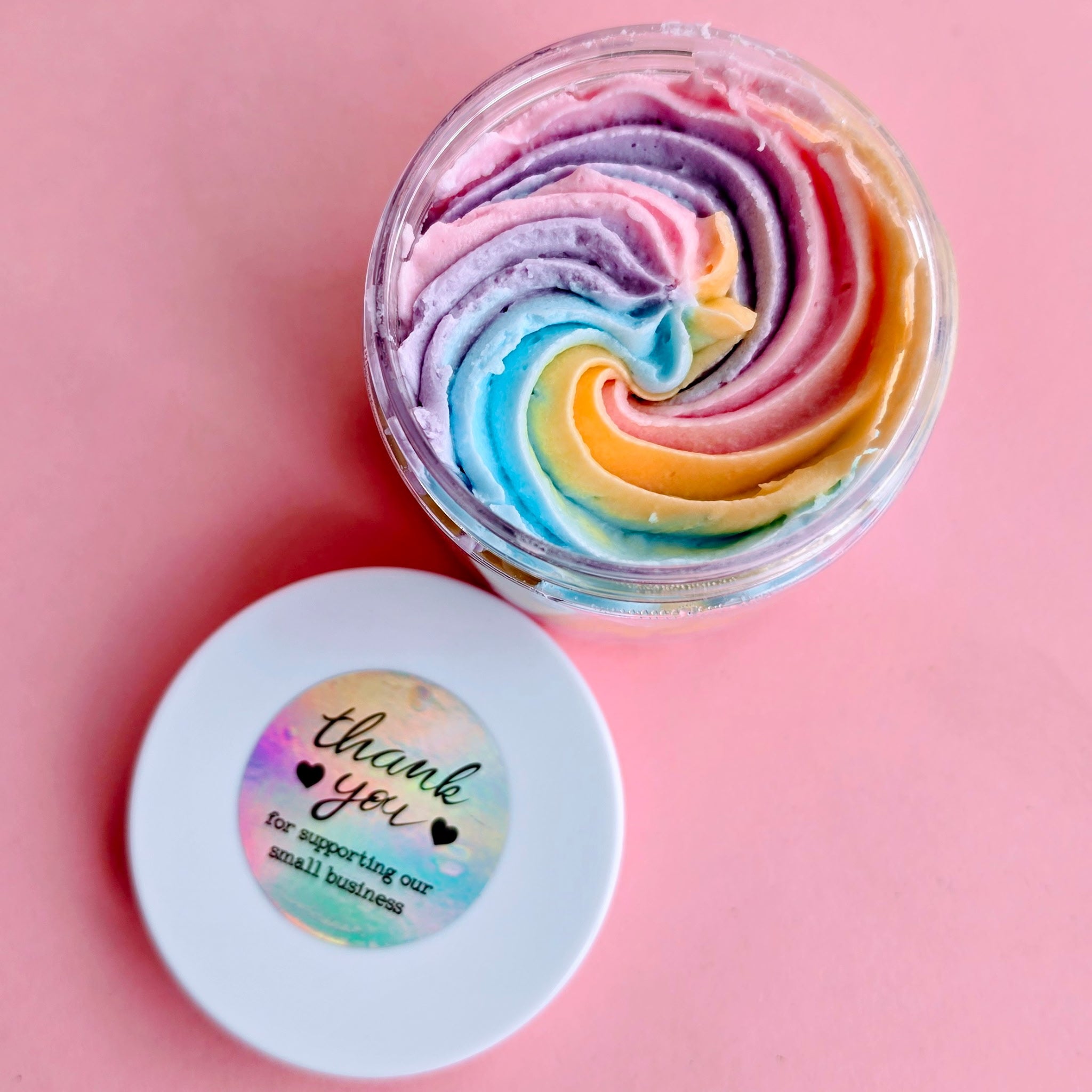 Colorful swirled product in a clear container with a 'thank you' sticker on a pink background