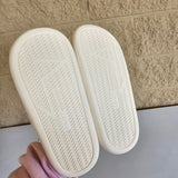 Two white bottoms slippers being held against a tiled floor background