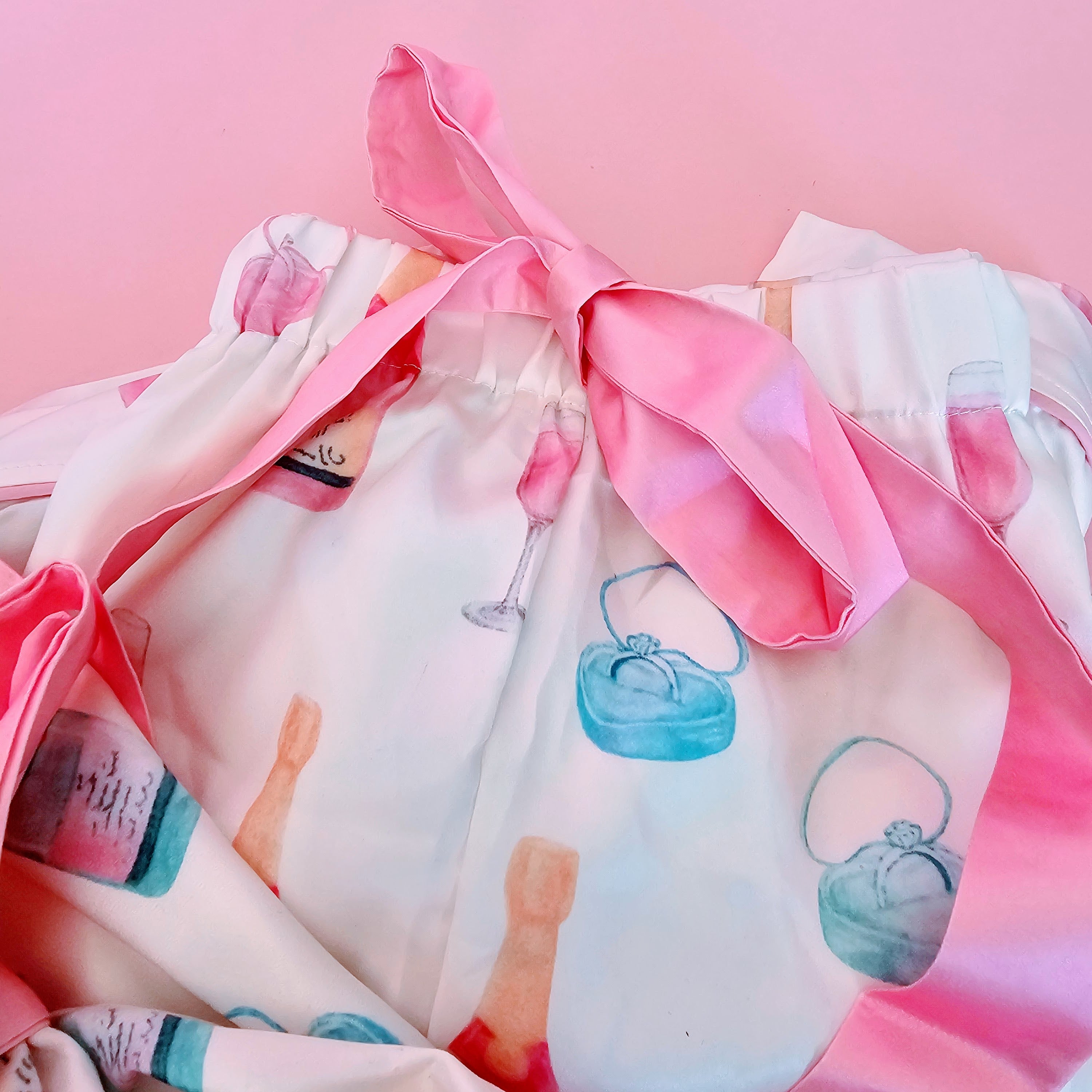 White and pink bridal pajamas with champagne bottle and ring pattern and pink bow