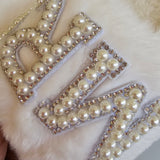 Decorative letters made of pearls on a white fur background