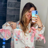 White and pink bridal pajama set with champagne bottles and engagement ring print, perfect for wedding morning and getting ready photos