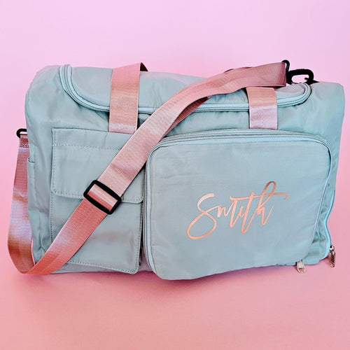 Personalized sage green carry-all duffel bag with mauve handles and rose gold foil name, perfect for travel, honeymoon, and everyday use