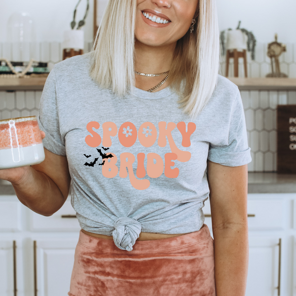 Spooky Bride tee, ash-colored bridal shirt, retro bride t-shirt, fall bride apparel, Halloween bride tee, pumpkin patch bridal wear, autumn wedding attire, colorful spooky bride shirt, bride to be casual outfit, Halloween-themed bridal top, pair with bride to be sunglasses