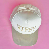 Tan and white trucker hat with embroidered “WIFEY” lettering on the front, a stylish accessory for brides and wives.