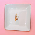 White ceramic trinket tray ring dish with gold trim and gold letter monogram, perfect for engagement and wedding day jewelry